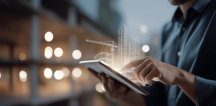 A hand on a tablet showing a digital model of a building under construction